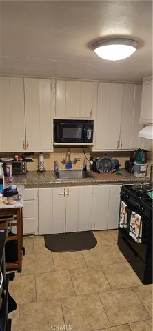 a kitchen with stainless steel appliances a stove a sink a stove and white cabinets