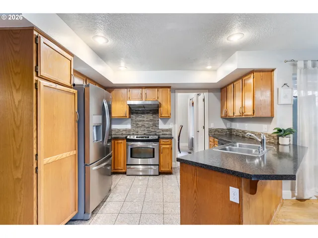 a kitchen with granite countertop a refrigerator and a stove