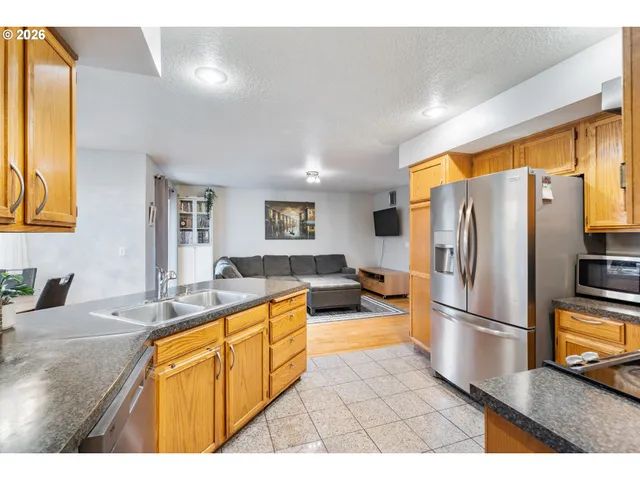 a kitchen with stainless steel appliances granite countertop a sink refrigerator and cabinets