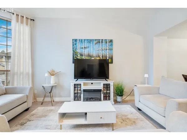 a living room with furniture a flat screen tv and a window