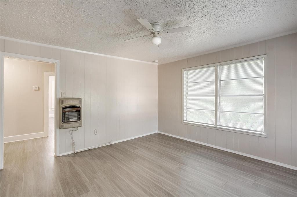 1411 6th Avenue, Unit 2 Fort Worth, TX 76104 - Photo 15 of 21 an empty room with wooden floor a ceiling fan and windows