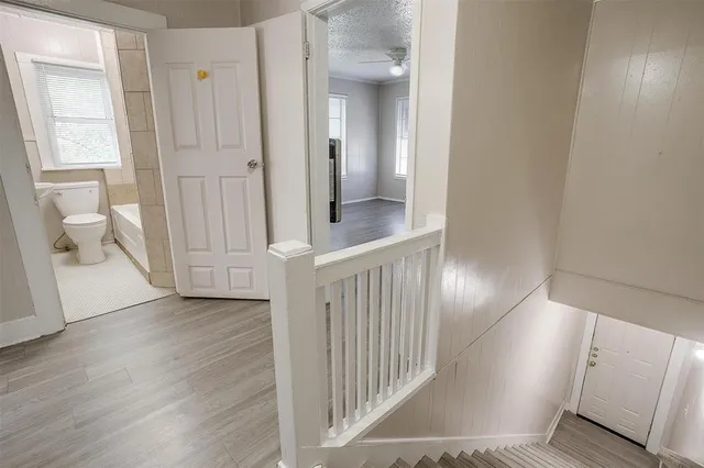 a view of a hallway with wooden floor and a living room
