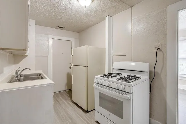 a kitchen with a stove cabinets and refrigerator