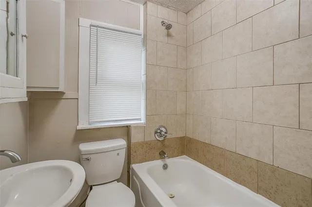 a white bath tub sitting next to a white toilet