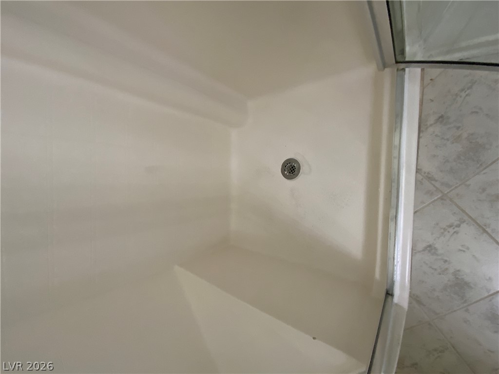 7400 West Flamingo Road, Unit 1039 Las Vegas, NV 89147 - Photo 30 of 40 A well-maintained shower stall featuring an integrated bench and tile flooring beyond.