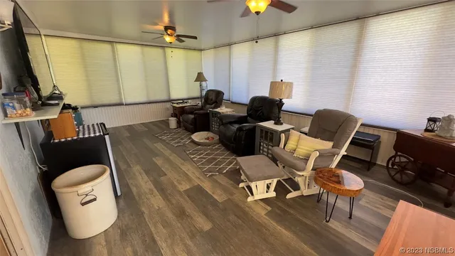 a living room with furniture a flat screen tv and a large window