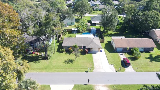 an aerial view of a house with a yard and lake view