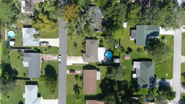 an aerial view of a house with a yard and large trees