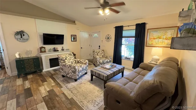 a living room with furniture a flat screen tv and a fireplace