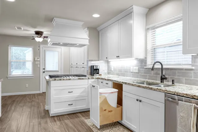 a kitchen with granite countertop white cabinets and white appliances