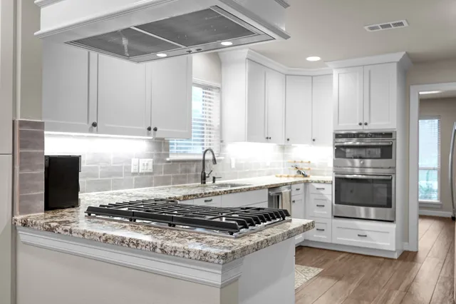 a kitchen with granite countertop a stove and a sink