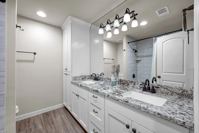 a bathroom with a sink double vanity granite and a mirror