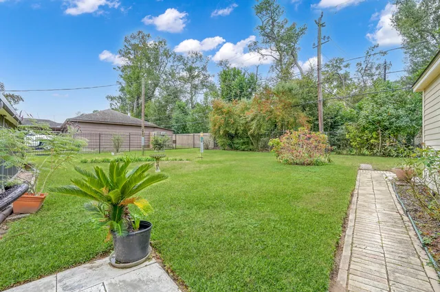 a view of an house with backyard space and a tree