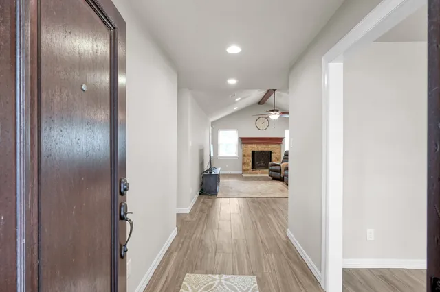 a view of a living room with a fireplace and wooden floor