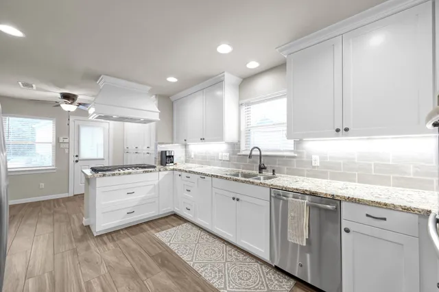 a kitchen with granite countertop white cabinets and white appliances