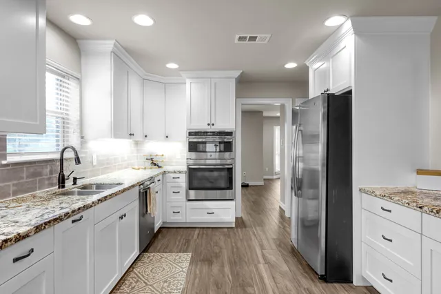 a kitchen with a sink stainless steel appliances and cabinets