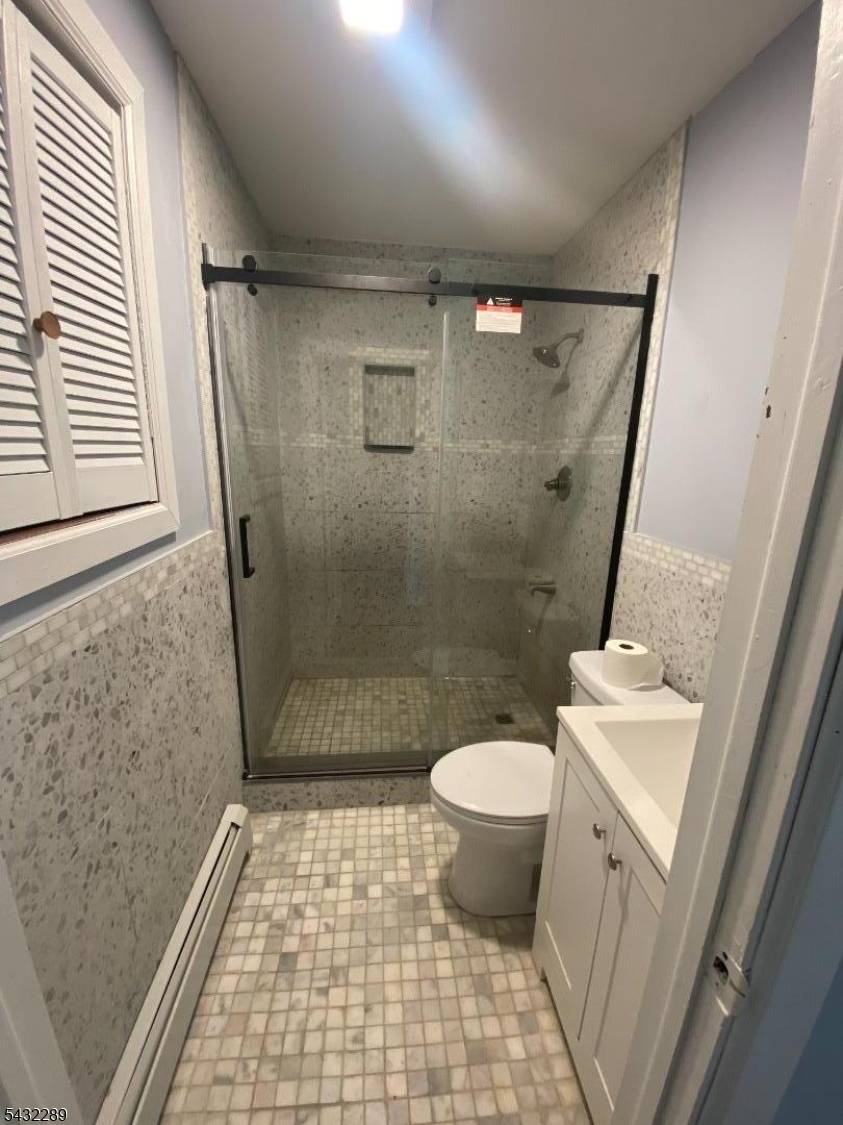 17 Walnut Terrace Bloomfield, NJ 07003 - Photo 9 of 18 a bathroom with a sink a toilet a mirror and shower