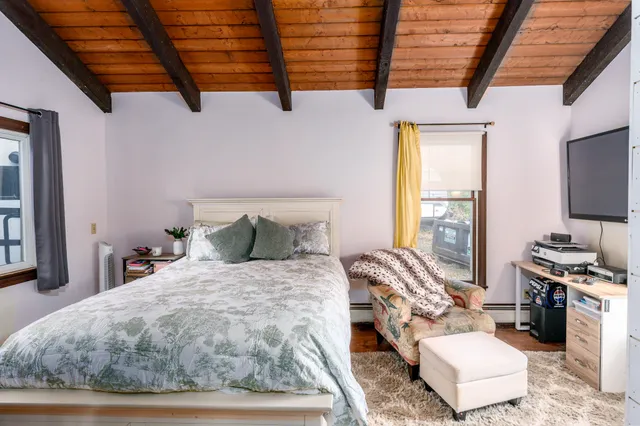 a large bed sitting in a bedroom next to a window