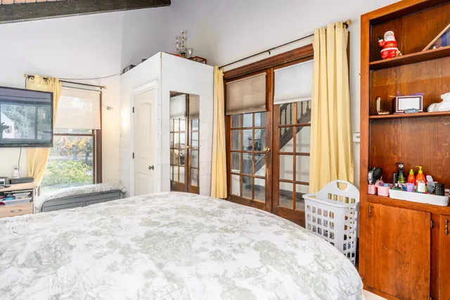 a bedroom with a bed and a large window with the outer view