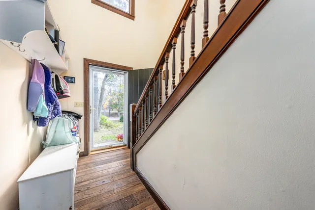 a view of staircase with lots of frames on wall and wooden floor