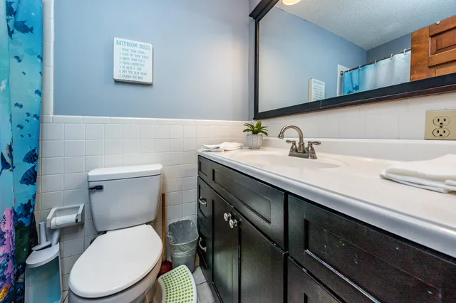 a bathroom with a toilet sink and mirror