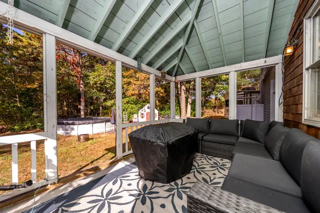 a living room with furniture a flat screen tv and a large window