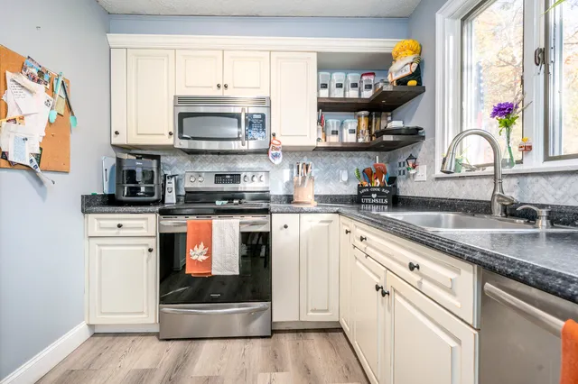 a kitchen with stainless steel appliances granite countertop a stove a sink and a microwave