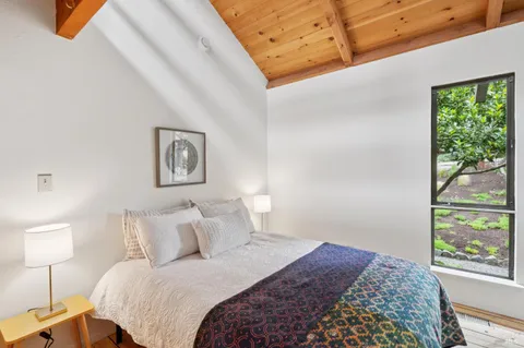 a bedroom with a bed and a large window