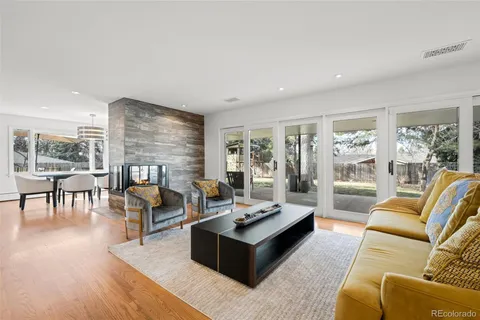 a living room with fireplace furniture and a large window