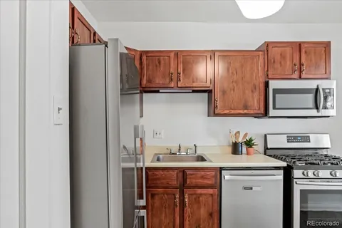 a kitchen with stainless steel appliances granite countertop a refrigerator and a stove top oven