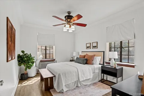 a bedroom with a bed a chandelier and dresser