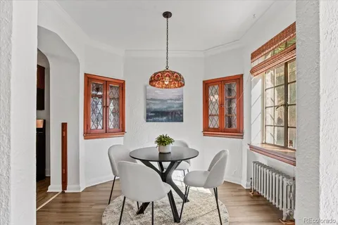 a dining room with furniture a chandelier and wooden floor