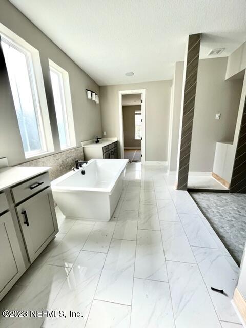 3880 Eagle Rock Road Middleburg, FL 32068 - Photo 2 of 7 a spacious bathroom with a double vanity sink a mirror and a bathtub