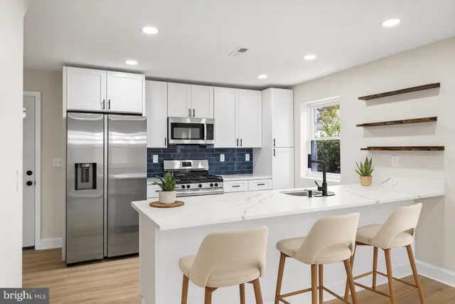 a kitchen with kitchen island a refrigerator stove microwave and cabinets