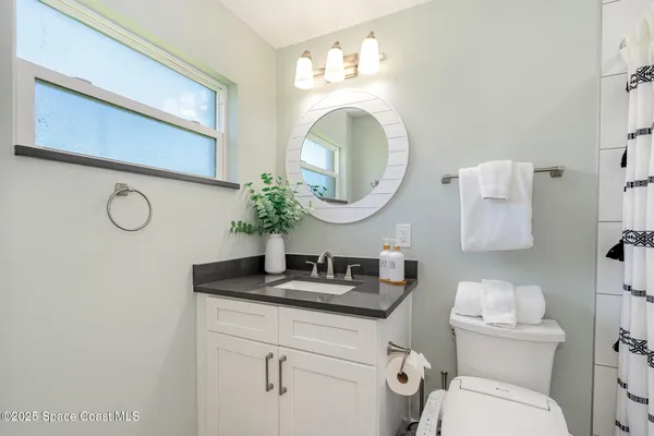 a bathroom with a toilet a sink and a mirror