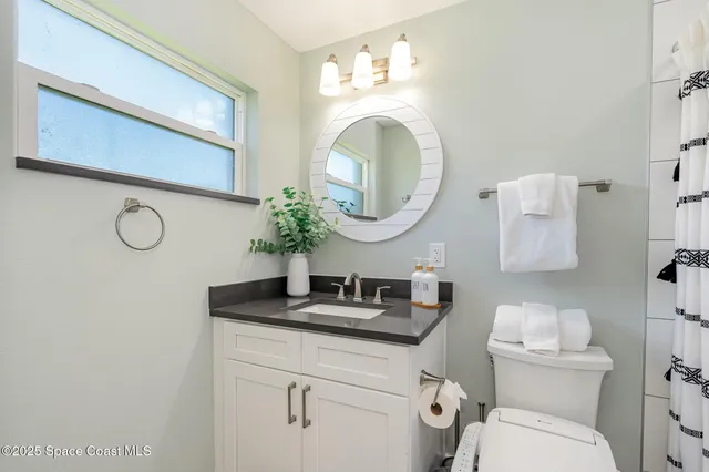 a bathroom with a toilet a sink and a mirror