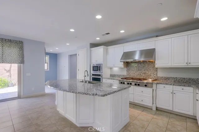 a kitchen with granite countertop a sink stove and cabinets