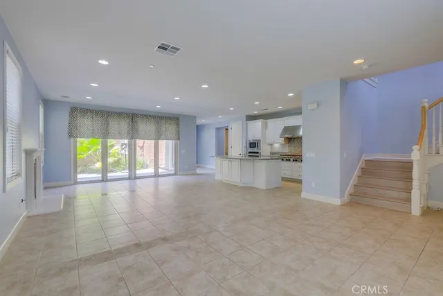 an empty room with windows and fireplace