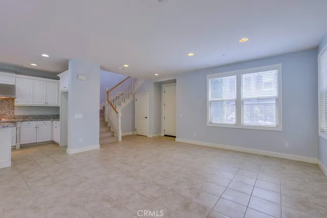 a large kitchen with stainless steel appliances kitchen island granite countertop a refrigerator and a sink