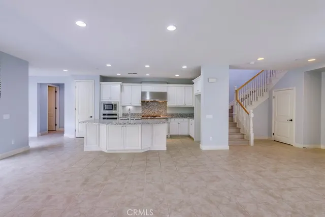 a kitchen with granite countertop a stove sink and cabinets
