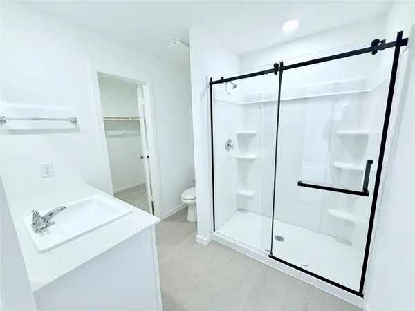a bathroom with a shower sink and mirror