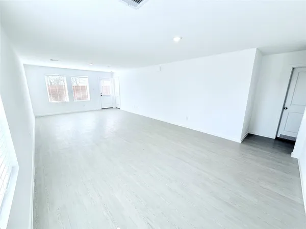 an empty room with wooden floor and window