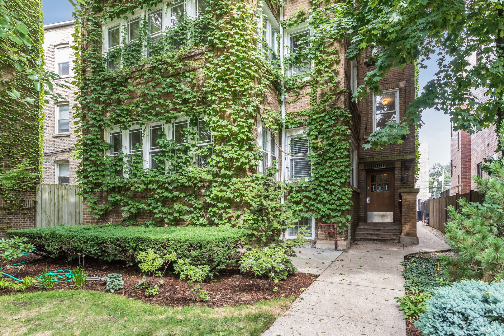 6967 North Sheridan Road, Unit 1 Chicago, IL 60626 - Photo 2 of 21 a front view of a house with a garden