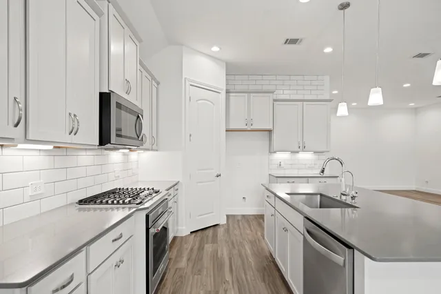 a kitchen with a sink stove and cabinets