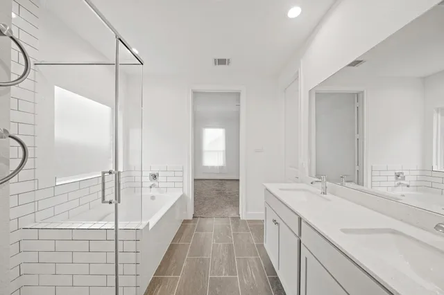 a spacious bathroom with a double vanity sink a mirror and a shower