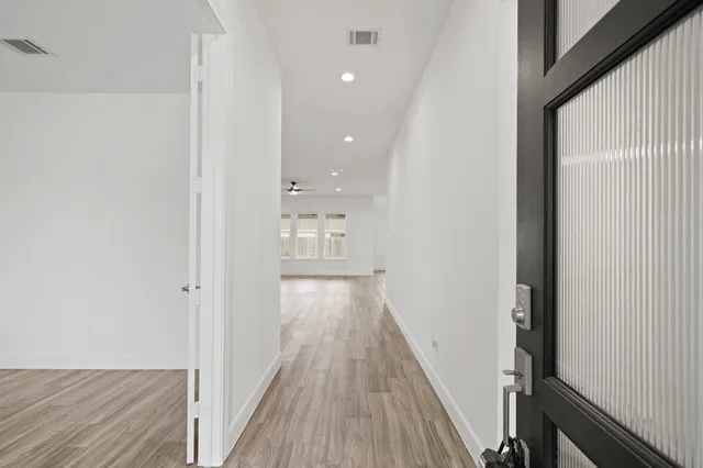 a view of a hallway with wooden floor