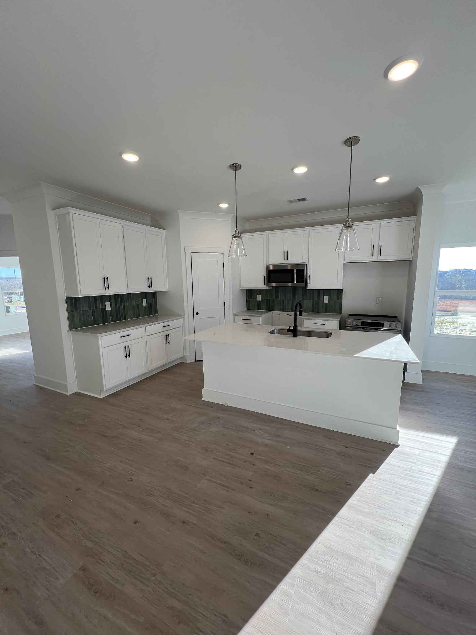 304 Strong Street Columbia, TN 38401 - Photo 4 of 49 a large white kitchen with kitchen island a sink a stove and a refrigerator