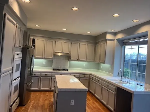 a kitchen with stainless steel appliances granite countertop a sink a stove and a refrigerator