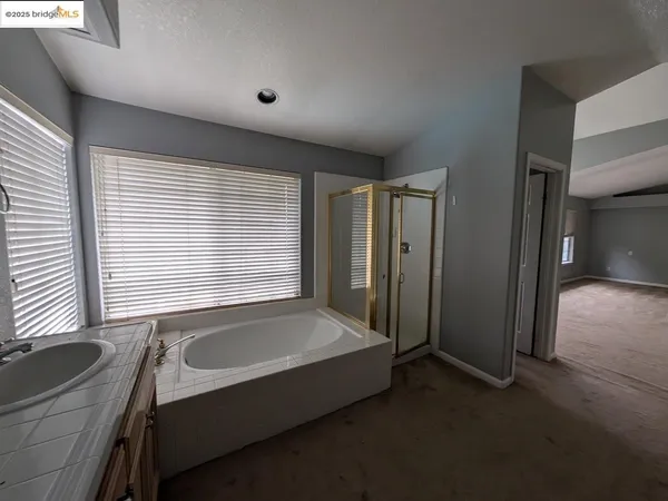 a bathroom with a tub sink and mirror