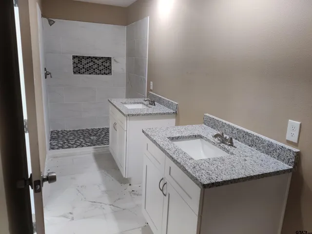 a bathroom with a granite countertop sink and a mirror